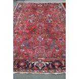 A Heriz rug woollen carpet on red ground,