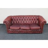 A red buttoned leather three seater Chesterfield settee