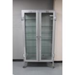 An early twentieth century Allan & Hanburys ltd metal double door surgical cabinet with glass