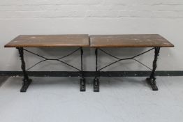 A pair of rectangular bar tables on cast iron legs