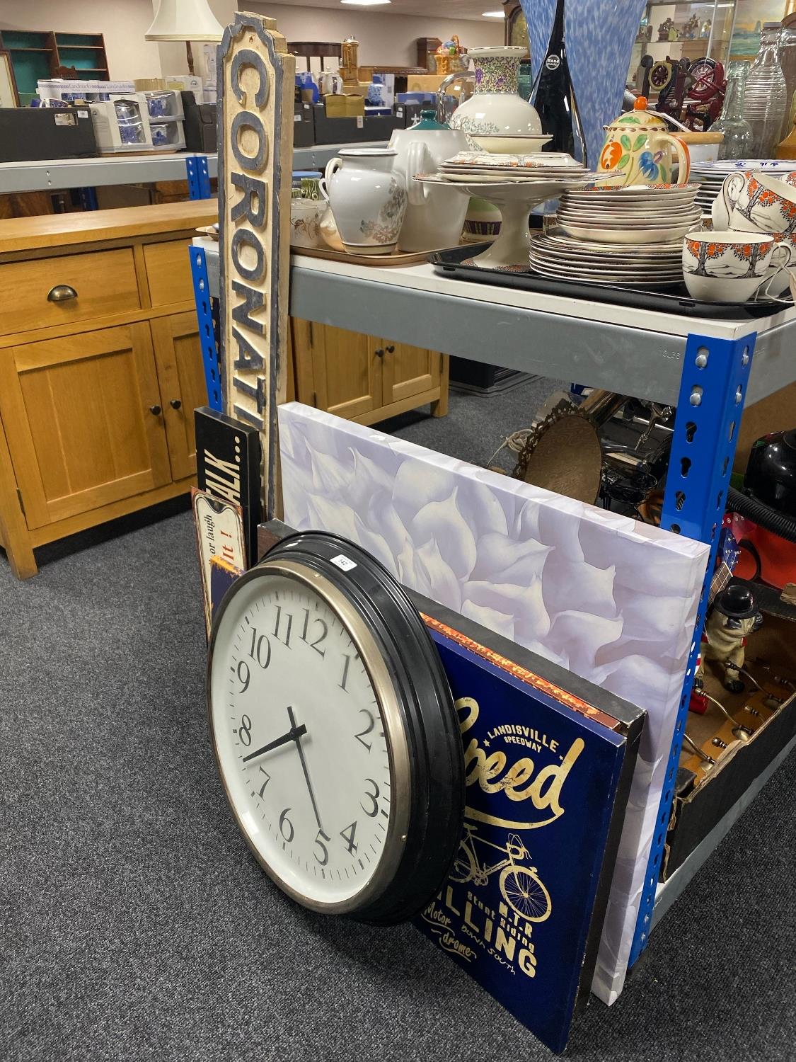 A battery operated wall clock, assorted signs,
