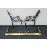 An antique brass extending fire curb and a pair of cast iron garden bench ends