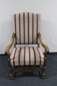 An early twentieth century oak armchair upholstered in striped fabric