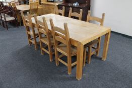 A contemporary oak dining table together with a set of six ladder back chairs