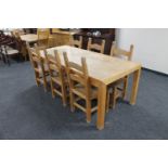 A contemporary oak dining table together with a set of six ladder back chairs