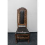 An antique carved oak leather upholstered hall chair
