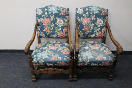 A pair of carved oak scroll arm armchairs in floral fabric