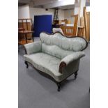 A 19th century mahogany framed shaped backed settee in green classical fabric