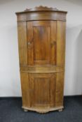 A 19th century continental pine bow fronted double corner cabinet