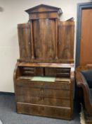A nineteenth century mahogany barrel fronted bureau fitted with four drawers and four cupboards