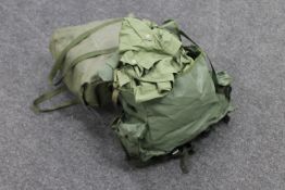 Two military back packs containing military clothing and accessories