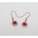 A pair of 14ct rose gold ruby and diamond earrings, the rubies weighing 2.