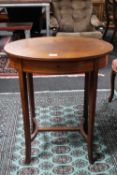 An inlaid mahogany oval work table containing sewing accessories