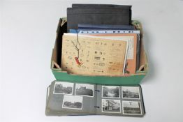 A box of four albums of stamps, monochrome photographs, two Meccano instruction booklets,