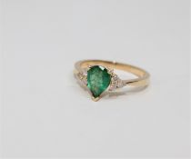 A 14ct gold emerald and diamond ring, the pear-cut emerald weighing 0.