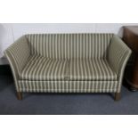 A mid 20th century continental two seater settee in striped fabric