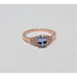 A 14ct rose gold sapphire and diamond ring, the oval-cut sapphire weighing 0.