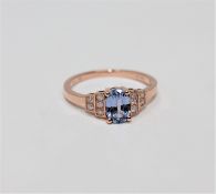 A 14ct rose gold sapphire and diamond ring, the oval-cut sapphire weighing 0.