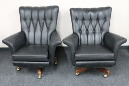 A pair of mid twentieth century black vinyl buttoned armchairs on teak swivel bases