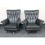 A pair of mid twentieth century black vinyl buttoned armchairs on teak swivel bases