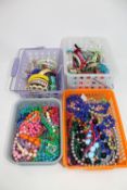 Four baskets of costume bangles and bead necklaces