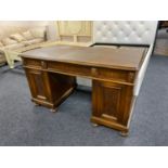 An early twentieth century oak twin pedestal desk on bun feet