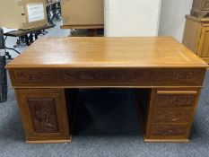 A carved Oriental twin pedestal writing desk fitted with six drawers