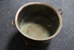 An antique copper twin handled log bin on raised feet