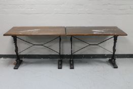 A pair of rectangular bar tables on cast iron legs