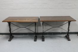 A pair of rectangular bar tables on cast iron legs