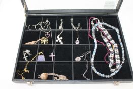 A jewellery display box containing nine various silver gem set pendants,
