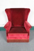 An early 20th century wing back armchair in red dralon