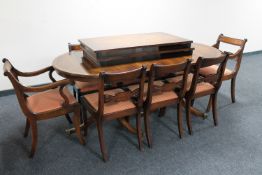 An inlaid mahogany twin pedestal dining table together with two extension leaves and eight chairs