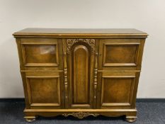 A stained beech sideboard fitted with four cupboards