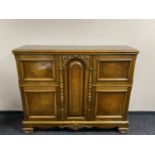 A stained beech sideboard fitted with four cupboards