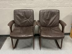 A pair of twentieth century leather armchairs on metal legs