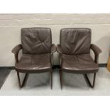 A pair of twentieth century leather armchairs on metal legs