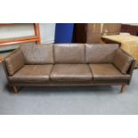 A mid 20th century Danish brown leather three seater settee