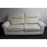 A three seater settee in oatmeal colour fabric