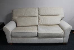 A three seater settee in oatmeal colour fabric