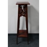 A reproduction carved mahogany plant stand