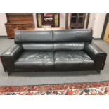 A Natuzzi black leather three seater settee on chrome support,