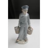 A Lladro figure of a young girl carrying buckets