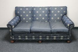 A traditional style three seater settee in blue fabric