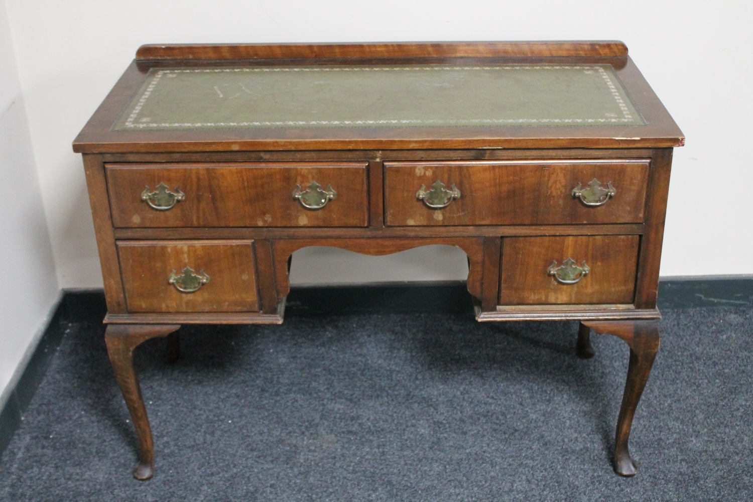A walnut desk on cabriole legs fitted four drawers