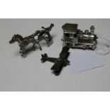 Three miniature silver models of a locomotive, a horse and trap and an aeroplane,