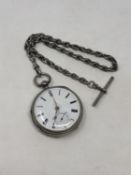 A heavy silver antique pocket watch on silver Albert chain