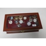 A coin collector's cabinet containing fourteen various modern pocket watches