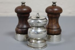 A pair of silver mounted salt and pepper mills together with one other white metal grinder.