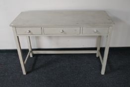 A painted pine three drawer side table